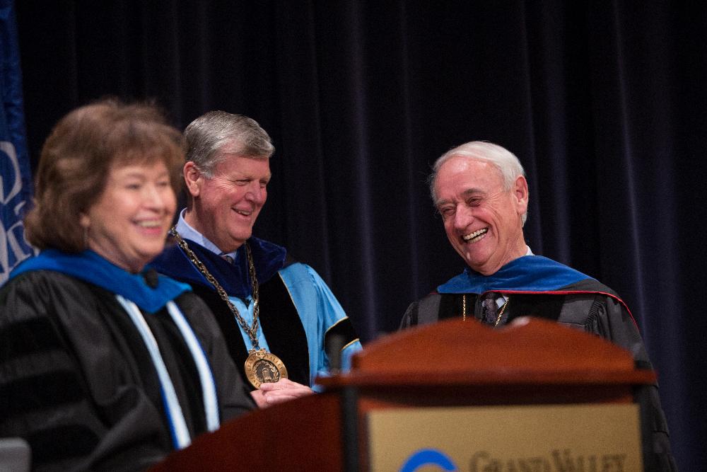 President Emeritus Haas and a faculty member smile while listening to remarks.